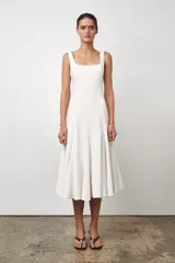 Vestido midi blanco de Zara Woman Collection, con escote cuadrado y sin mangas. Corte al cuerpo con falda evasé. Cierre con cremallera oculta en la costura.
