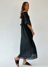 Vestido midi color coral, de textura arrugada, con escote redondo, mangas cortas con volados y ruedo con flecos.