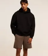 Bermuda masculina de corte slim fit, color marrón, confeccionada en algodón con felpa. Presenta cintura elástica con cordón ajustable y bolsillos laterales.