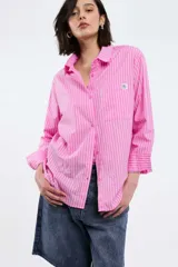 Camisa a rayas verticales rojas y blancas, de corte recto, con cuello clásico, manga larga y bolsillo en el pecho.