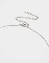 Collar corto dorado con cadena de eslabones pequeños, dijes de trébol de cuatro hojas y dijes redondos con cristales engarzados.