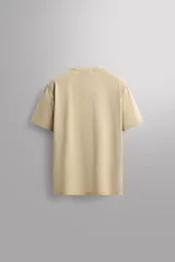 Camiseta deportiva de entrenamiento, corte regular fit, color gris claro, con cuello redondo y manga corta. Confeccionada en tejido técnico ligero y elástico con estructura Quick Dry nivel 2. Presenta costuras planas y un pequeño logo estampado en la parte inferior derecha.