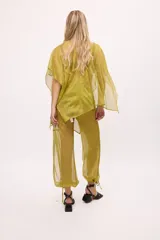 Pantalón negro traslúcido con corte ancho y ajuste en los tobillos.