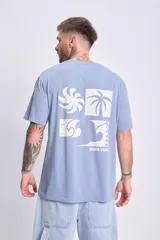 Camiseta de manga corta celeste con corte oversize y estampa en la espalda con un diseño de cuatro recuadros con motivos playeros y la frase "Pura Vida".