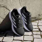 Championes Adidas Response W, color negro con detalles plateados y suela blanca.