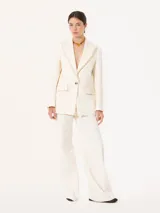 Pantalón de vestir blanco, de corte recto y amplio, confeccionado en jacquard. Se ajusta a la cintura con cierre, gancho pantalonero y botón interno.