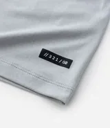 Remera deportiva de hombre color beige, manga corta, cuello redondo y corte ajustado. Presenta costuras raglán y una pequeña etiqueta en el dobladillo de la manga.