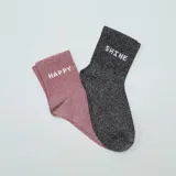 Pack de dos pares de medias cortas con brillos: un par rosa con la palabra 'Happy' y un par negro con la palabra 'Shine'.