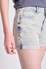 Short de jean color celeste con tachas plateadas en el frente, de tiro alto y ruedo desflecado.