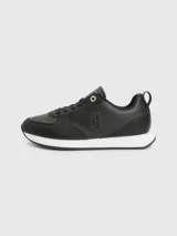 Zapatillas deportivas Tommy Hilfiger negras de cuero sintético, con cordones y suela blanca.