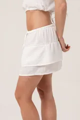 Minifalda blanca de lino con cintura elastizada y doble volado.