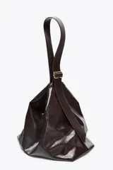 Bolso maxi shopper color marrón oscuro, con asa ancha ajustable con hebilla. Incluye bolsillo interno con cierre de cremallera metálica y cierre imantado.