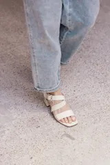 Sandalias negras de cuero con tiras anchas cruzadas y hebilla metálica plateada. Taco cuadrado de altura media.