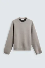 Jersey color gris topo de punto con cuello redondo y manga larga.