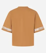 Blusa boxy de mangas cortas amplias, confeccionada en algodón, con cuello redondo y detalle de entremedios en las mangas.