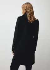 Abrigo negro de corte recto con doble botonadura, cuello con solapa de pico, bolsillos frontales con solapa y forro interior.