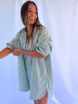 Camisa oversize a rayas verticales verdes y blancas, con cuello clásico y mangas largas abullonadas.