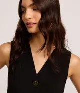 Chaleco negro de crepé con escote en V y abotonadura dorada. Corte slim y sin mangas.