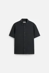 Camisa celeste de corte recto, manga corta y cuello solapa.