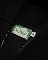 Canguro negro con capucha y cierre frontal, con texto bordado en el pecho y bolsillos laterales.