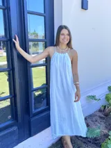 Vestido largo blanco de lino con breteles finos y escote recto.