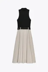 Vestido midi con falda beige con botones y cuerpo negro de cuello alto y sin mangas. Incluye cinturón negro con hebilla plateada.
