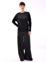Buzo negro de tejido de punto con cuello redondo y mangas largas, decorado con apliques de strass en el canesú.