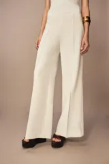 Pantalón blanco de tiro alto y pierna ancha, con cierre lateral oculto.
