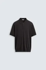 Polo negro de punto tejido en hilatura con algodón y lyocell, corte regular fit, cuello solapa con cierre frontal de botonadura, manga corta y acabados en rib.