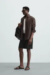 Bermuda negra de lino con calce relajado. Presenta cintura elástica ajustable con cordón, bolsillos frontales y un bolsillo trasero de plastrón.