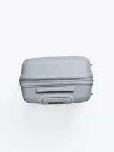 Valija rígida de viaje color gris con diseño de líneas horizontales. Cuenta con manija extensible, ruedas giratorias y cierre con combinación.