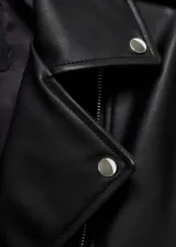 Chaqueta negra de cuero sintético con forro interior, cuello de solapa, trabillas en los hombros, cierre de cremallera frontal, bolsillos con cremallera, diseño entallado y manga larga.
