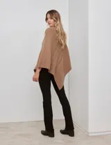 Poncho tejido color negro, con cuello polera y diseño de trenzas diagonales en el frente. Presenta un corte asimétrico en el ruedo.