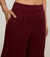 Bermuda de sastrería color borgoña, con cierre descentrado, trabillas en la cintura y pliegues delanteros.