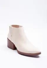Botas marrones de símil cuero, tipo texanas, de caña baja y punta fina.