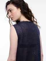 Musculosa sin mangas color gris, tejida en hilado con brillo sutil. De calce relajado y largo por debajo de la cadera, presenta aberturas laterales.