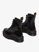 Bota de cuero negra con cordones, plataforma alta y costuras amarillas.