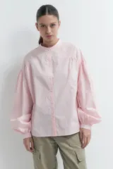 Camisa oversized de manga larga color rosado, con botones delanteros y diseño holgado.