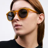 Lentes de sol redondos con montura de policarbonato color amarillo y lentes polarizados negros.