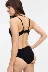 Bralette blanco de microfibra seamless con escote en V y diseño de olas. Sin copa ni aro, con breteles ajustables y cierre trasero de tres posiciones.