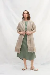 Chal de tejido liviano confeccionado en lana 100% sin teñir, color marrón, con detalle de flecos en los extremos.