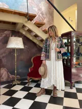 Chaqueta corta negra con bordados florales en tonos rosa, verde y amarillo.