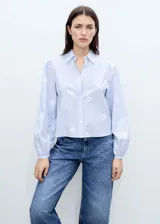 Camisa celeste a rayas verticales con bordado floral blanco, cuello camisero, manga larga abullonada y cierre frontal con botones.