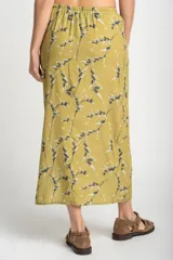 Falda midi color verde oliva con estampado de ramas y hojas en tonos grises y blancos. Tiene cintura elastizada con cordón ajustable y un tajo lateral.
