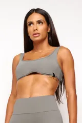 Top deportivo gris con escote cuadrado, breteles anchos y calce ajustado. Incluye forro interno y apertura para almohadilla removible.