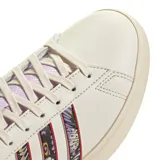Championes Adidas Grand Court 2.0 color crema con detalles de mariposas en las tres tiras laterales y detalles en lila en el talón, lengüeta y cordones.