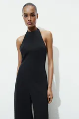 Mono largo negro de cuello halter y espalda descubierta, con pierna ancha. Cierre en espalda con cremallera oculta en costura y botones.