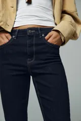 Pantalón de jean azul oscuro, de corte bootcut, tiro alto y cinco bolsillos.