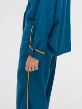 Pantalón de vestir color ladrillo, de corte holgado y tiro alto, con caída recta y detalle de diseño al costado.