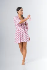 Bata kimono corta de algodón estampado con flores rojas, violetas y verdes. Tiene mangas al codo y lazo de ajuste en la cintura.